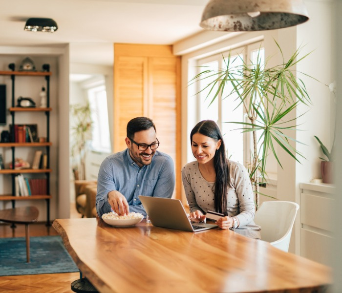 Couple applying for rate reset on a laptop in a stylish room at home