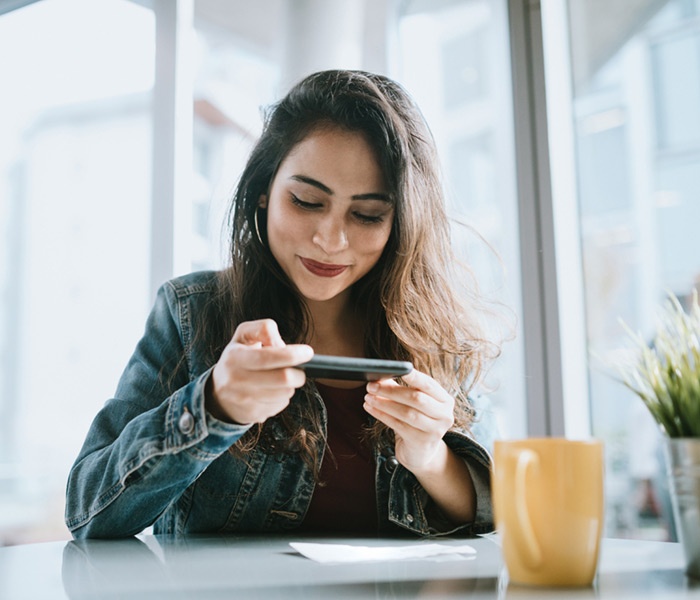 Woman taking photo of check on her phone for mobile deposit