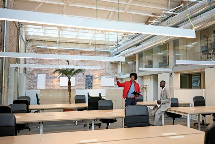 Office building meeting room with woman and man looking at the architecture