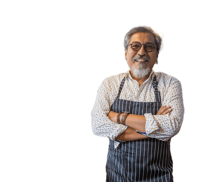 Older man in work apron with arms crossed